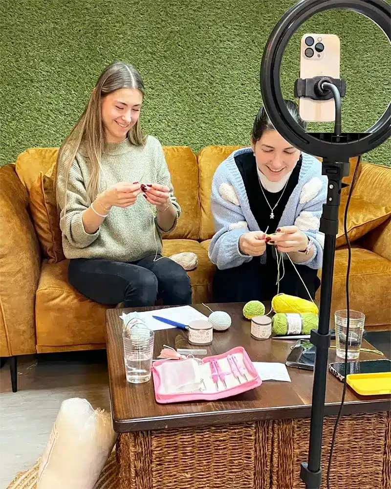 Live-Aufzeichnung für TikTok bei Frida’s Wollhaus mit zwei Mitarbeiterinnen beim Häkeln auf dem Sofa